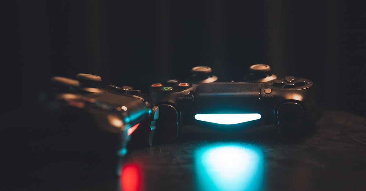 Gros plan sur des manettes de jeu lumineuses sur une surface sombre, créant une ambiance mystérieuse.